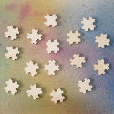 Pack of 16 Natural Wooden Puzzle Piece Card Topper Embellishments, as shown